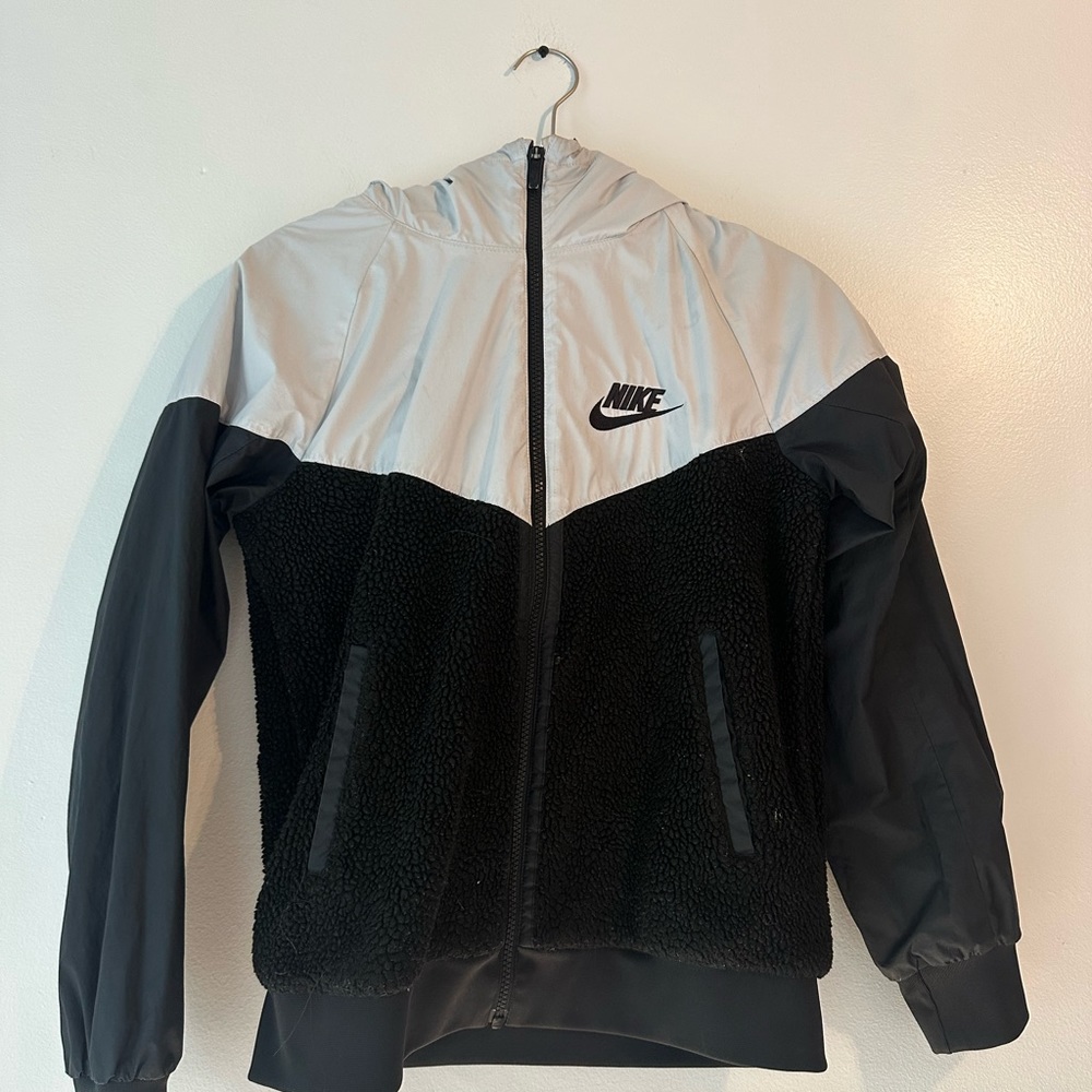 A slightly worn, grey and black fuzzy nike windbreaker jacket